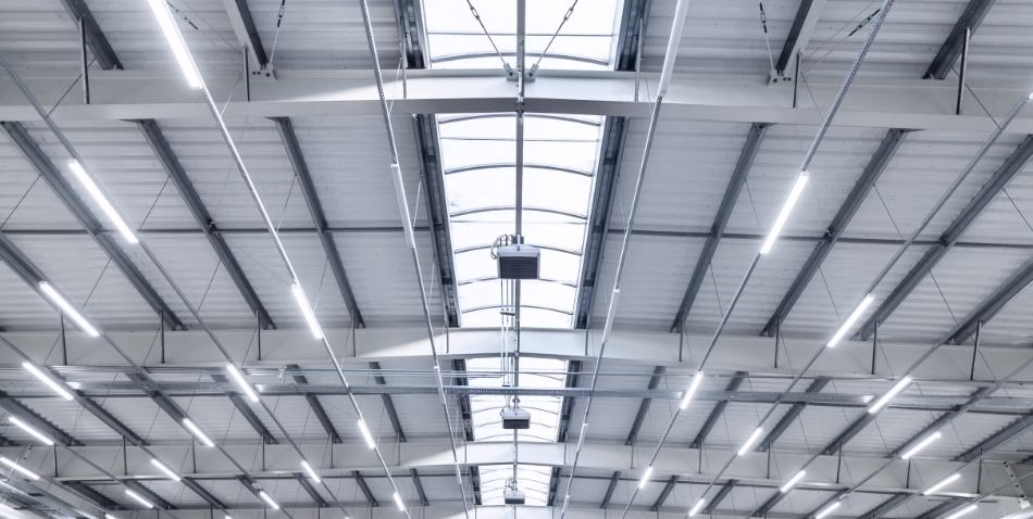 Vista do teto de um galpão com iluminação moderna.