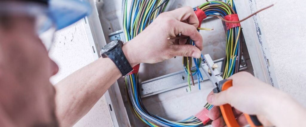 Eletricista organizando fiação elétrica colorida