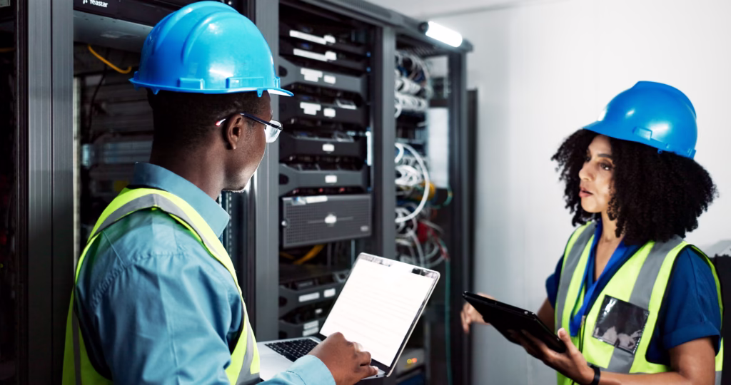 Técnicos em data center com dispositivos digitais